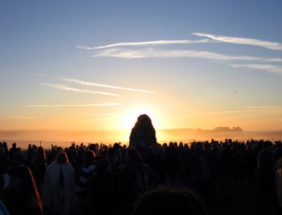 Le soleil du solstice d'été se lève derrière un menhir du site de Stonehenge